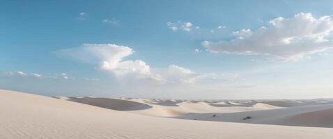 Expansive desert landscape with rolling sand dunes under a clear blue sky and soft clouds photo