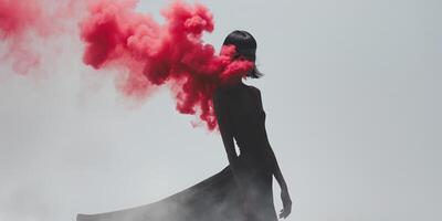 Silhouette of mysterious model posing in red smoke cloud. photo