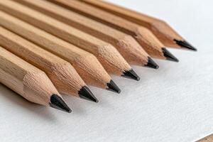 A close up of a row of unsharpened pencils on a white surface photo