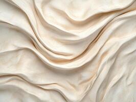 Abstract beige fabric background with flowing folds photo