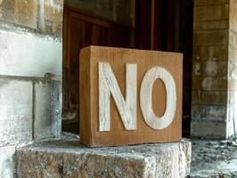 A large block with the word NO written on it in an abandoned building. photo