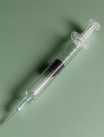 A syringe on a green background photo