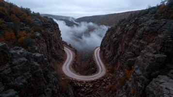 Winding road through a mountain pass with low clouds photo