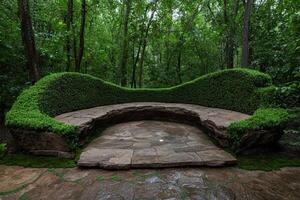 A stone bench with a green hedge in a lush forest photo