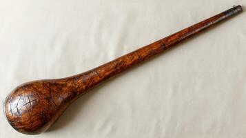 A wooden club with a bulbous head and a long handle photo