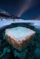 A frozen rock formation in a winter landscape under the night sky photo