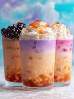 Three colorful boba drinks with whipped cream and toppings photo