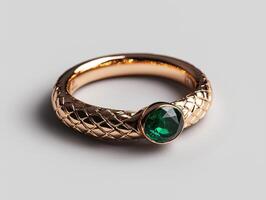 Elegant gold ring with emerald gemstone on white background photo
