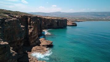 Rocky cliffs meet the turquoise sea on a sunny day photo