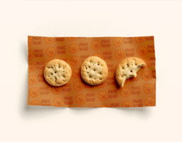 Three round cookies and a partial cookie rest on orange patterned paper psd