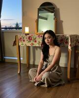Elegant Young Woman Sitting on Floor in Cozy Room with Mirror photo