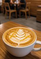 Coffee with beautiful latte art on wooden table in cafe photo