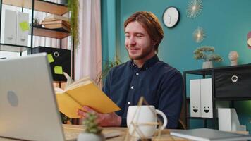 Business man reading book turning pages smiling enjoying literature taking a rest relaxing at office video