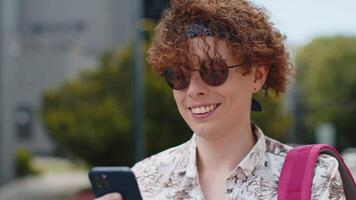 Happy tourist man using smartphone typing text messages browsing internet social media web app video