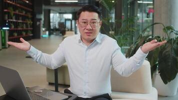 Angry businessman raising hands in indignant expression, asking reason of failure in office lobby video