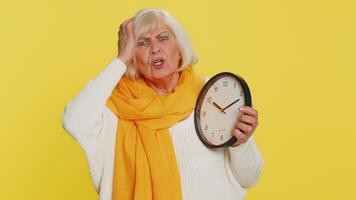 Senior old woman with anxiety checking time on clock, running late to work, being in delay, deadline video