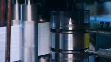 Shining metal vertical shaft spinning fast and moving a roll of fiber for future diapers. At the factory producing nappies. video