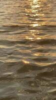 Golden sunset reflecting on gentle waves of tranquil water video