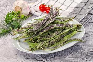 A plate of beans and vegetables on a table photo