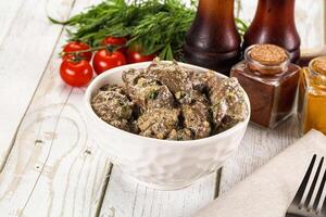 A bowl of meat and vegetables on a table photo