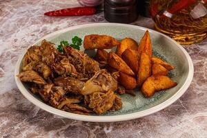 A plate of food with potatoes and meat photo