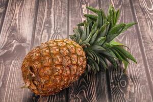 A pineapple sitting on a wooden table photo