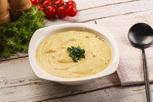 A bowl of soup with a spoon and a salad photo