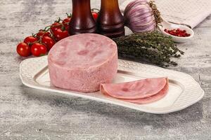 A plate with a ham and some vegetables on it photo