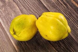 Two yellow fruits on a wooden table photo