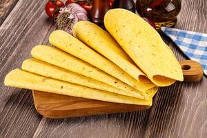 A wooden cutting board with several tortillas on it photo