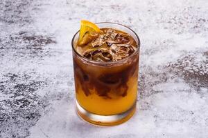 A glass of iced coffee with a lemon wedge photo