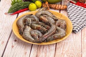 Fresh raw prawns in a bowl on a wooden table photo