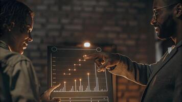 A midconversation snapshot of two team members one pointing at a holographic representation of an asset allocation chart emphasizing collaborative analysis.. photo