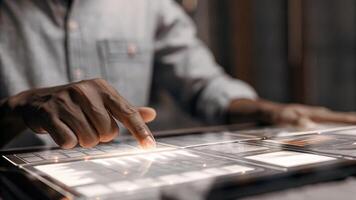 A closeup of a participants hand swiping through a holographic dashboard of investment options showcasing the ease of manipulating data during the strategy session.. photo