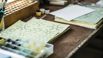 A close perspective of a cluttered workbench with pipettes test tubes and spontaneous drawings of molecular structures on paper capturing the essence of creative research.. photo