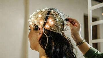 A medium closeup capturing the moment of activation as a neural interface headset pulsates with light while making contact with the human brain suggesting a dynamic relationship. photo