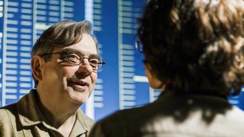 A middleaged man with glasses a slight smile playing on his lips engaging in a discussion about genetic modifications his portrait set against a backdrop of digital bioinformatics. photo