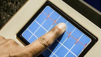 A human thumb against a biometric sensor pad that reveals an animated pulse rhythm overlay with varying colors representing emotional state and stress levels in a visually engaging. photo