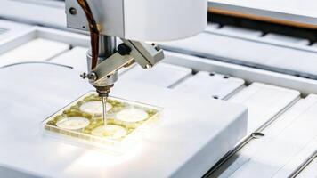 Closeup of a robotic arm precisely manipulating a Petri dish filled with genetically engineered cells with intricate machinery in the background highlighting automation in the lab.. photo