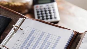 Closeup of an open folder revealing a detailed report on food metabolism related to genetic markers with a calculator and a list of grocery items in the background illustrating. photo