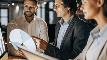 A focused exeive reviewing a holographic pie chart that displays customer segmentation surrounded by colleagues who are observing the data interactively.. photo