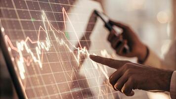 A closeup of a holographic chart depicting cryptocurrency trends with a user gesturing toward the display to manipulate the data in realtime.. photo