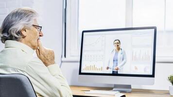 An elderly man sporting a thoughtful expression presses a finger to his chin while listening to a speaker on screen surrounded by digital charts and health data visualizations.. photo