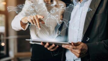 An exeive interacting with a holographic interface using hand gestures to manipulate data sets while a holographic map of global markets hovers in the air.. photo