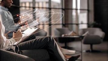 A participant takes notes while holographic images of market trends and competitor analysis swirl in the air offering realtime insights.. photo