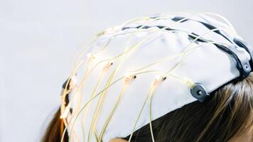Detailed view of a braincomputer interface headset featuring glowing electrodes that are delicately p on the scalp conveying energy and data transfer through vibrant color. photo