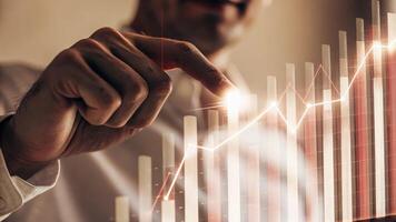 A holographic bar graph comparing different market competitors with a closeup on a male analyst using a gesture to zoom in on a specific trend.. photo