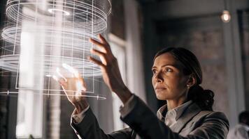 A focused businesswoman using hand gestures to manipulate a holographic presentation revealing intricate details layered within the projected data.. photo