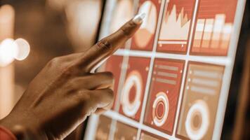 A closeup of a hand interacting with a glowing holographic interface selecting options on a virtual screen that displays company performance indicators and key performance metrics.. photo