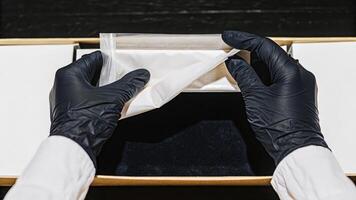 A pair of hands demonstrating the correct technique for donning nitrile gloves highlighting the importance of personal protective equipment integrity in biohacking activities.. photo